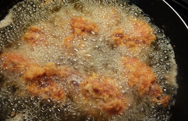 Chiên miếng gà trong chảo ngập dầu