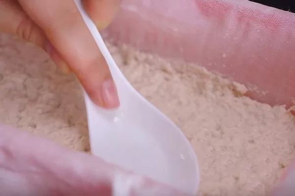 Dùng muỗng nén chặt và dùng vật nặng đè lên trên