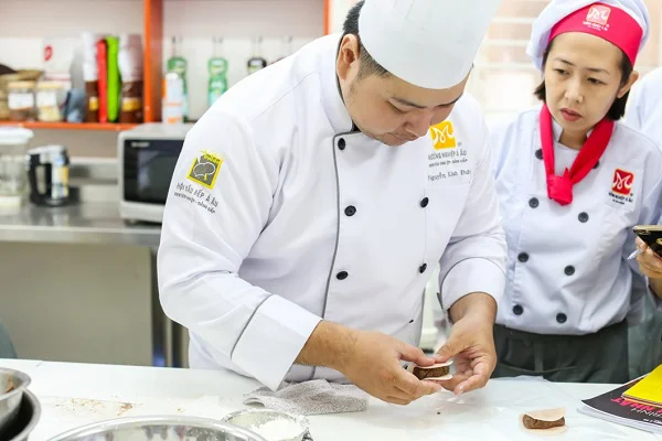 Thầy tập trung chỉ các bạn cách gói bánh