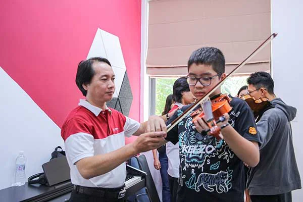 Giảng viên chỉnh sửa tư thế chơi đàn