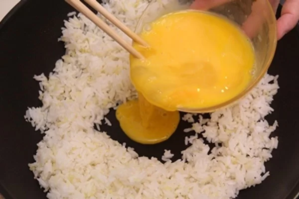 Cho trứng đã nêm gia vị vào trực tiếp rang với cơm