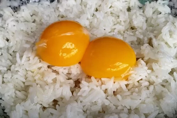 Trộn cơm và trứng trước khi rang.